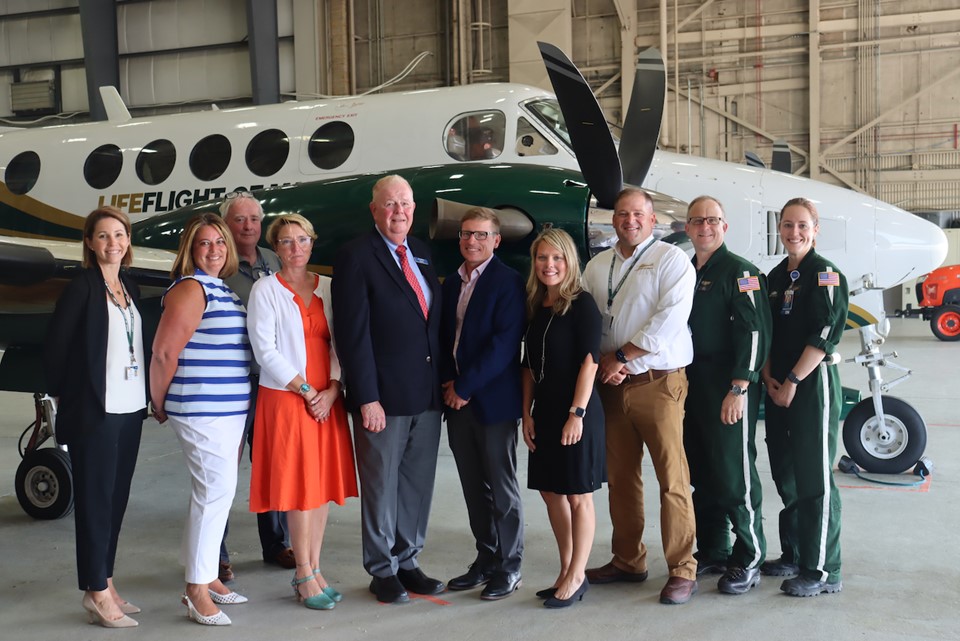 Representatives of Bangor Savings Bank and LifeFlight pose in front of a LifeFlight airplane