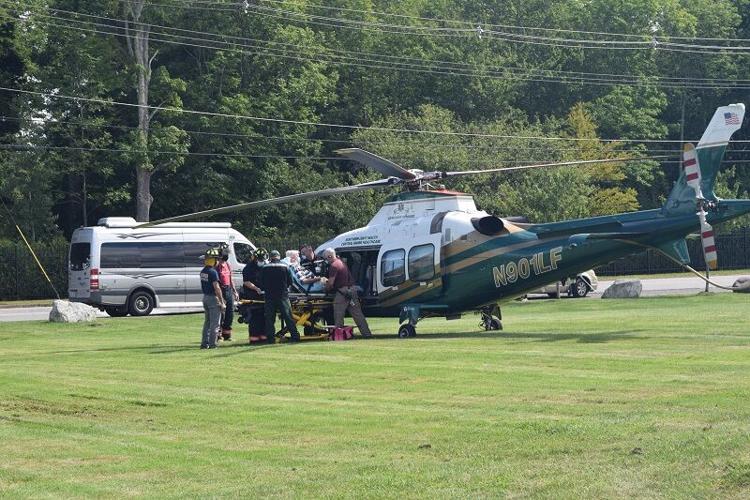 LifeFlight helicopter in a field, surrounded by first responders.