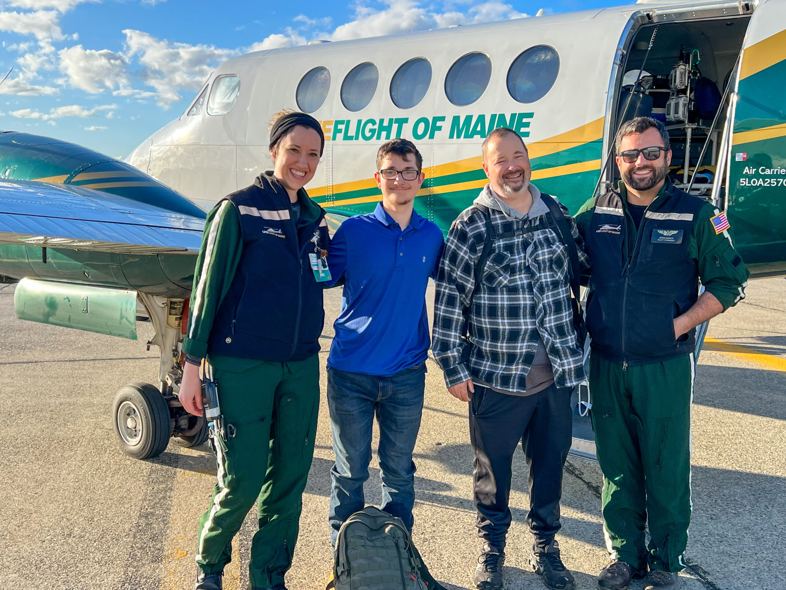 Four people standing in front of a LifeFlight airplane.