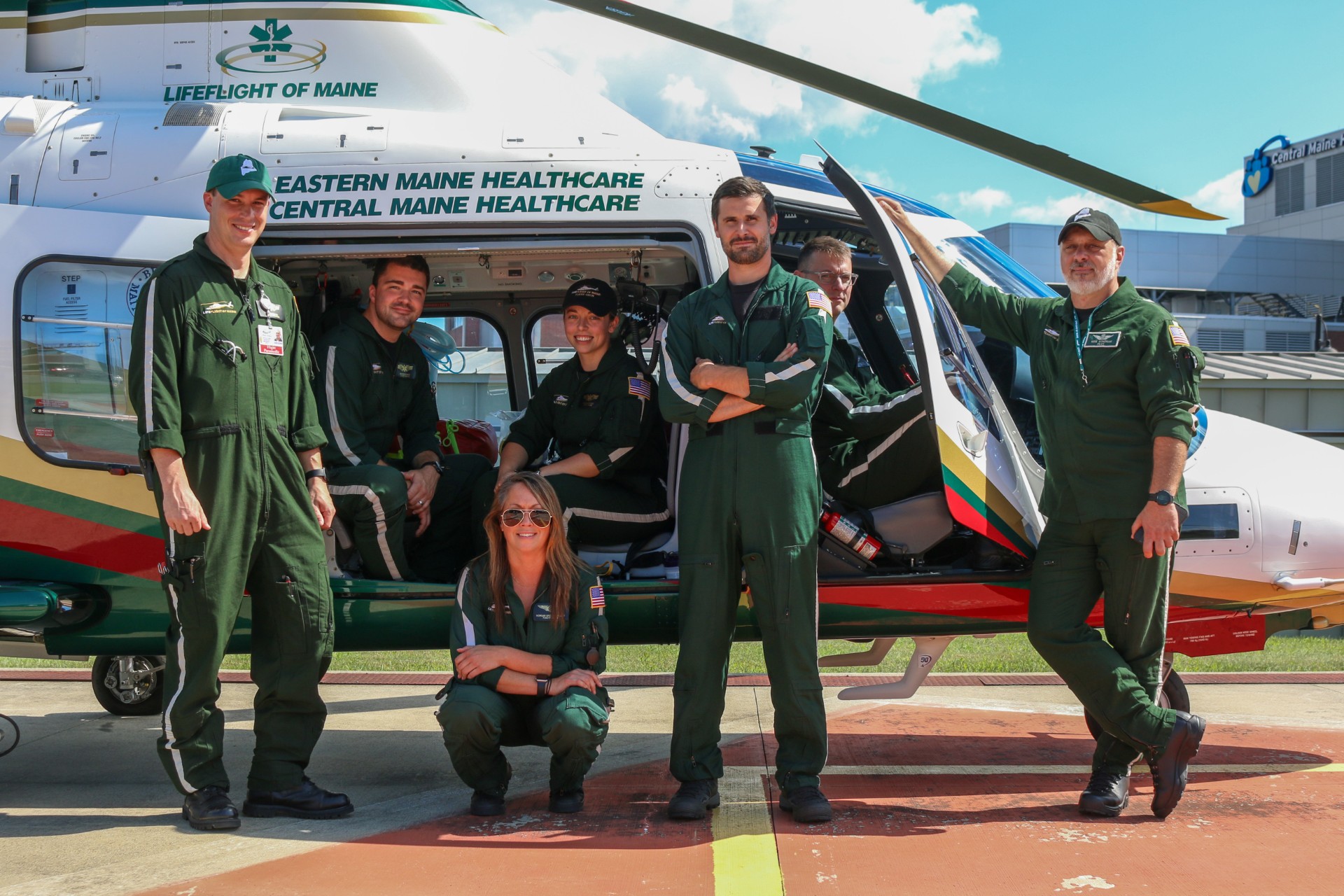 LifeFlight of Maine crew members stand outside with a helicopter.