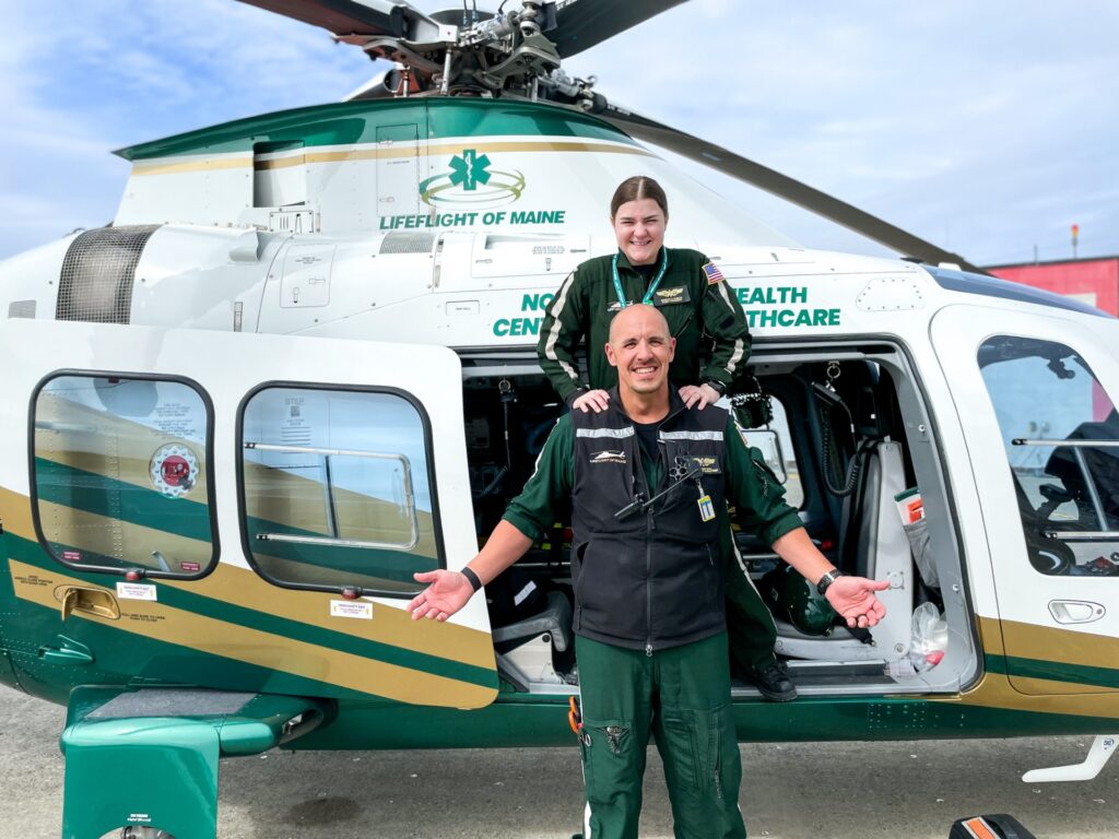 LifeFlight of Maine crew members stand outside with a helicopter.