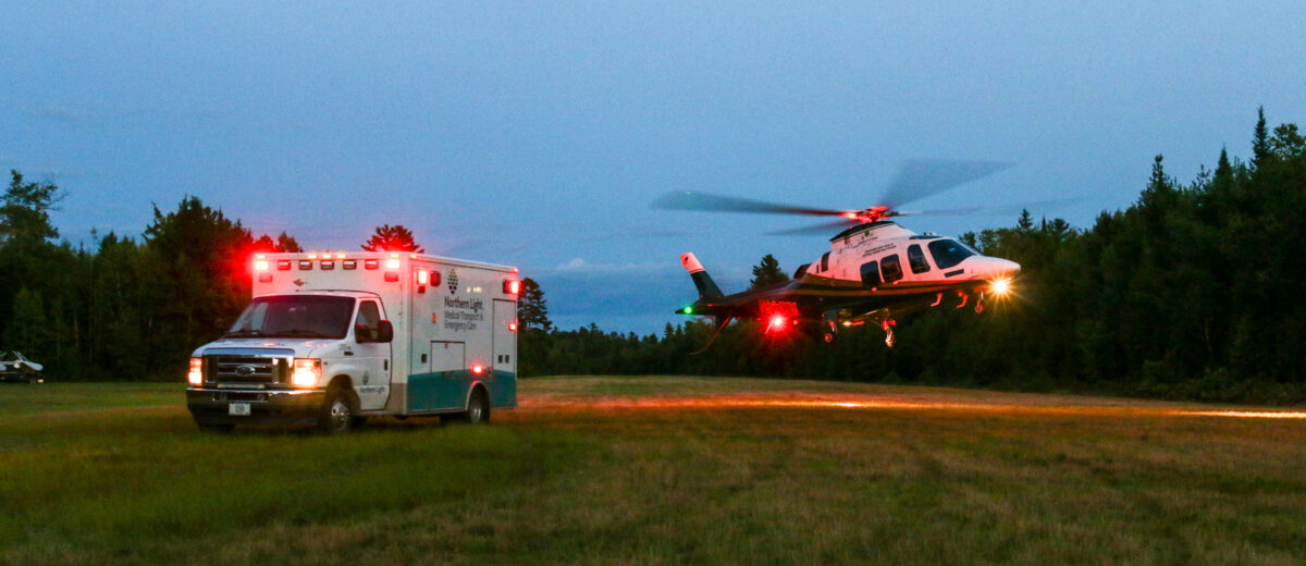 LifeFlight of Maine helicopter taking off next to an ambulance.