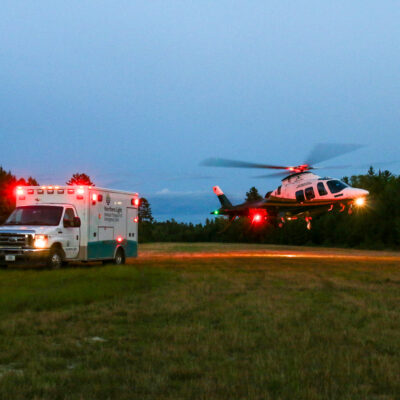 LifeFlight of Maine helicopter taking off next to an ambulance.