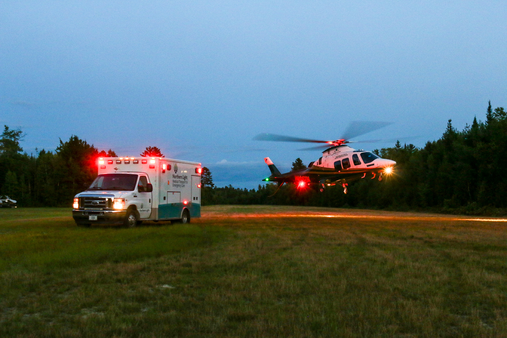 LifeFlight of Maine helicopter taking off next to an ambulance.